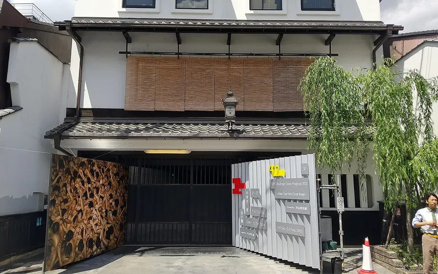 A KYOTOGRAPHIE venue in a Kyoto townhouse, with the exhibition board at its gate, 2025
