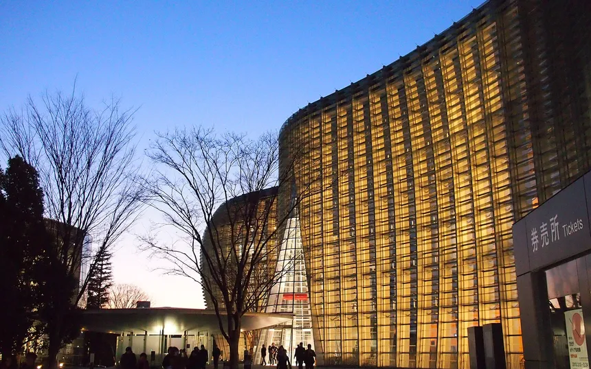 The glass facade of The National Art Center, Tokyo, the venue, at dusk