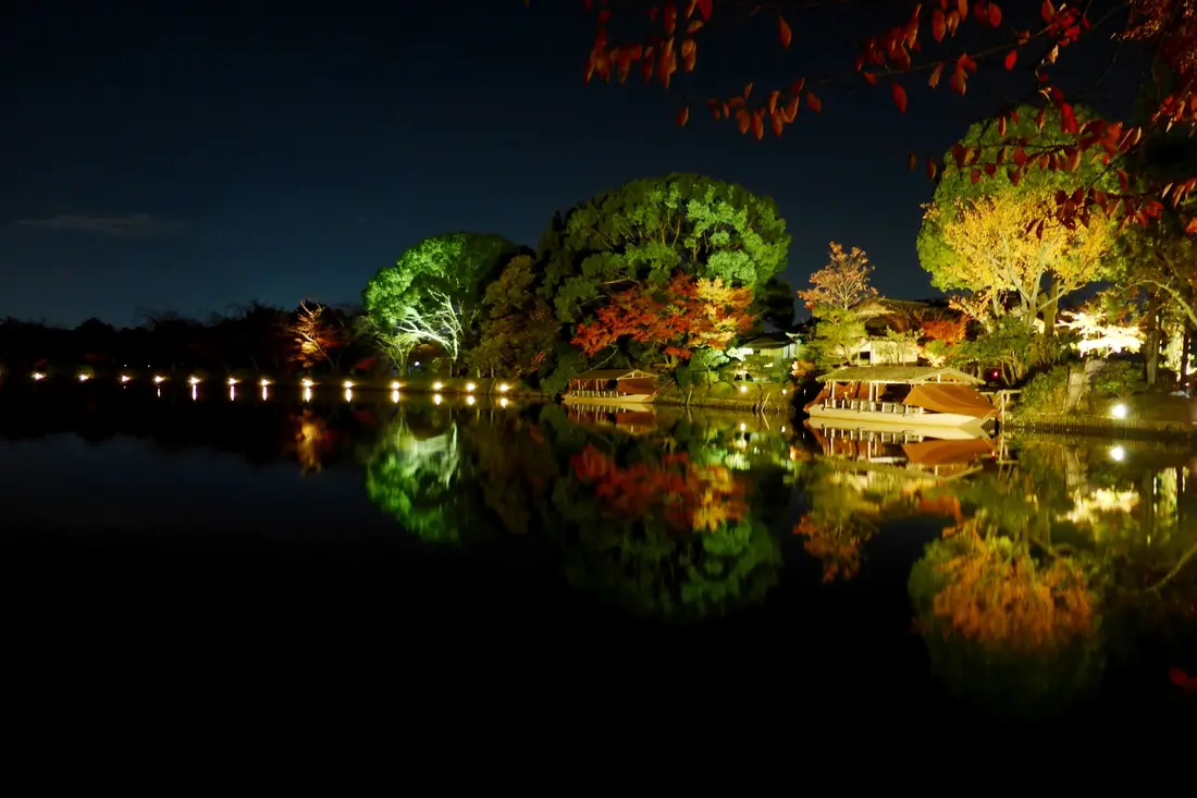 Osawa Pond at Daikaku-ji on an autumn evening, lit trees reflected in the water